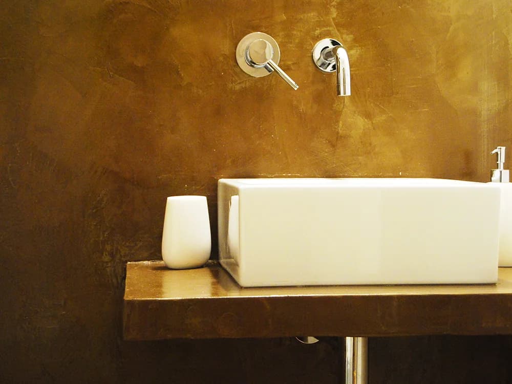 Lavabo e parete con finitura materica