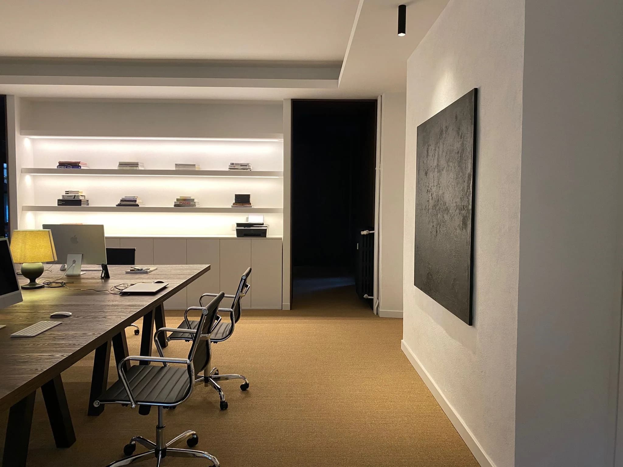 Postazioni di lavoro e libreria illuminata nello studio 2d casa a Saluzzo