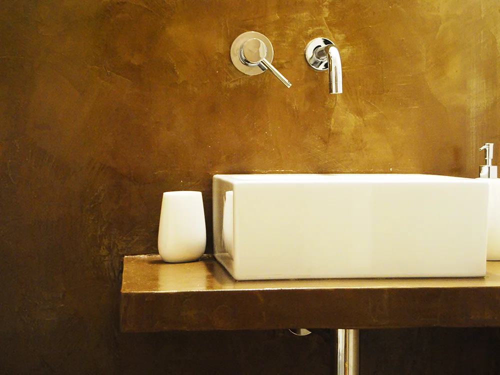 Lavabo e parete con finitura materica